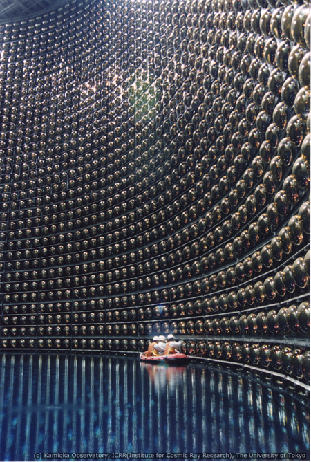 Maintenance workers inside the Super Kamiokande neutrino detector float on a rubber raft atop superpure water. (Kamioka Observatory, Institute for Cosmic Ray Research, The University of Tokyo)